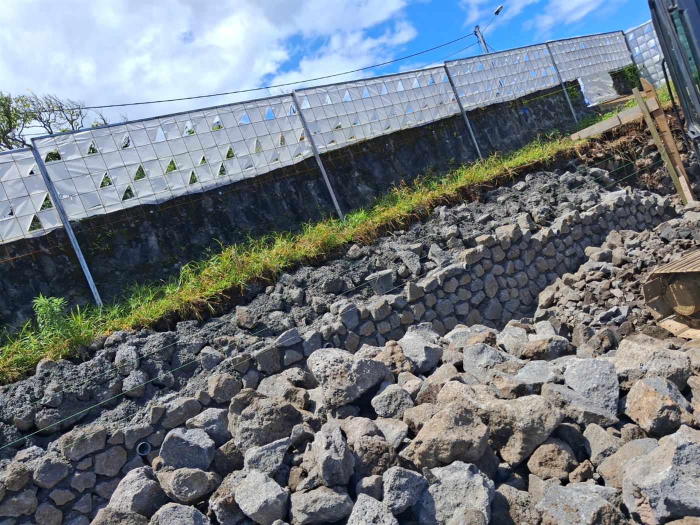 Montage d'un mur en moellons au-dessus d'un terrassement, chantier PGLA à La Réunion